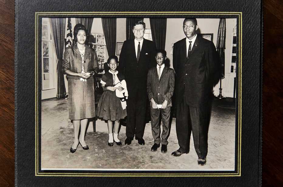 old black and white photo of myrlie evers williams and her family with then president john f kennedy
