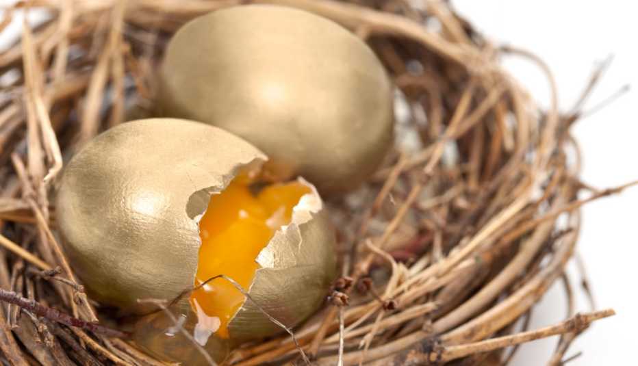 a cracked gold egg sits in a nest