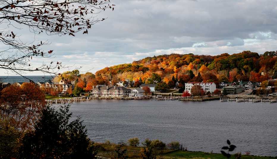 view of frankfort michigan with colorful fall foliage behind the town as seen from across betsie lake