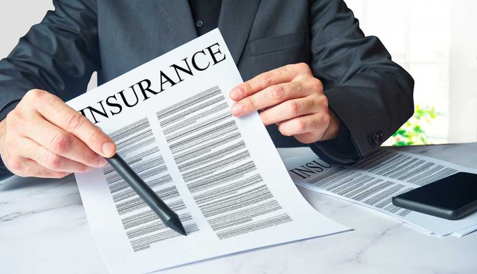 An insurance agent is presenting a policy contract  for an unseen client to sign