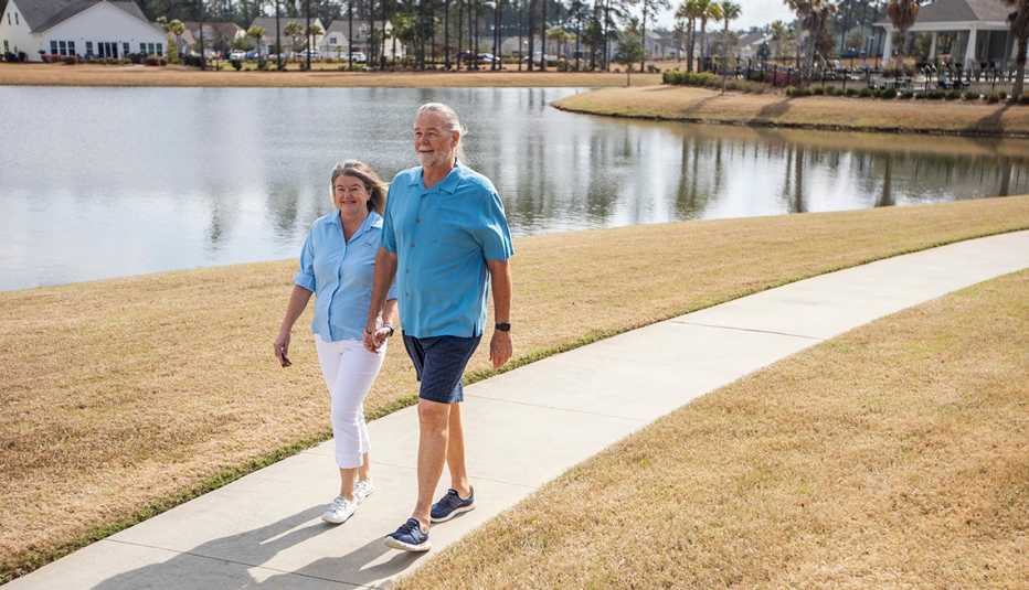 Linda (left) and Rob Nehrbas walk along a path at a park nearby their home at Four Seasons at Cane Bay Tuesday Feb. 21, 2023, in Summerville, S.C. 