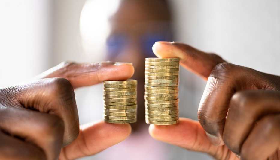 The racial wage gap is referenced by a man's hands holding two unequal stacks of coins. 
