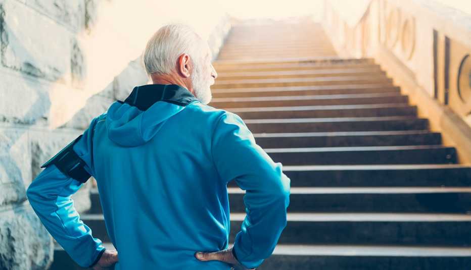 man in workout jacket prepares to climb steep staircase