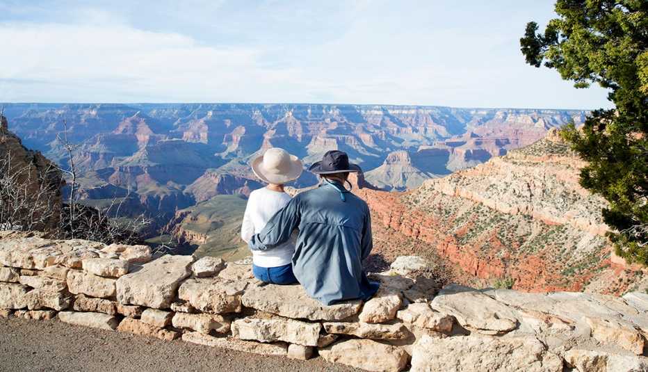 a couple sitting on the rim of the Grand Canyon