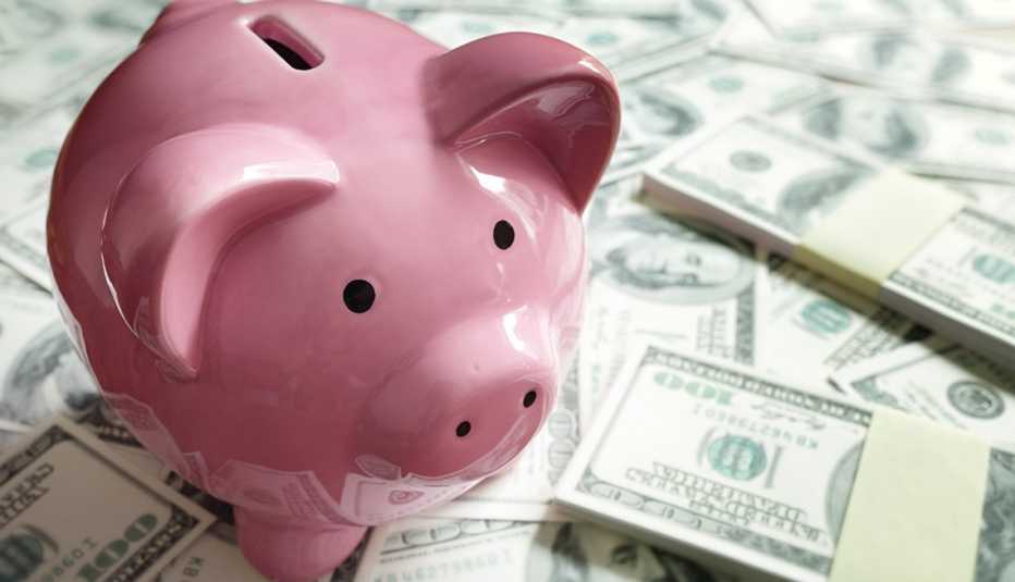 Piggy bank on money represents saving for retirement