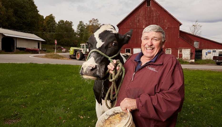 DeWitt Head and cow Crystal photographed in front of his farm in Brookfield, NY