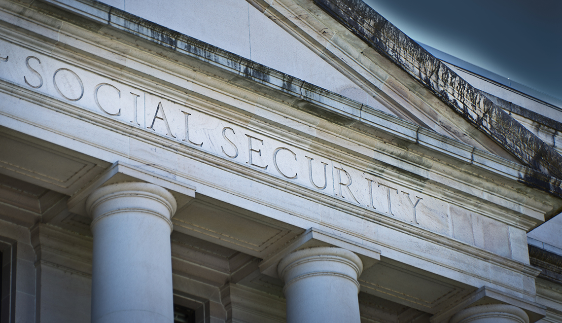 front of large marble greek architecture building with social security as the sign engraved on it