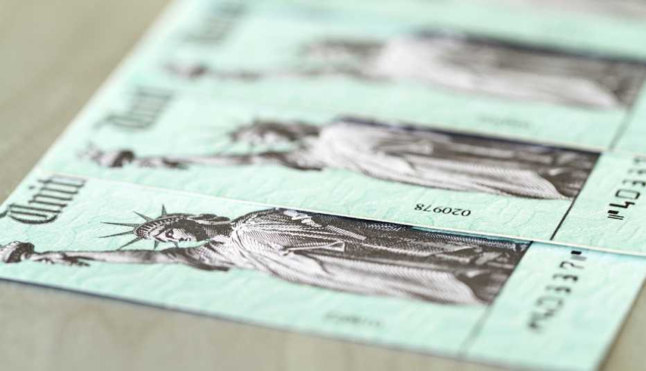 A line of US Treasury checks, like those used for  Social Security benefits, with selective focus on first check.