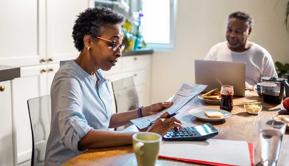 A senior couple going over their home finances seated at the kitchen table.