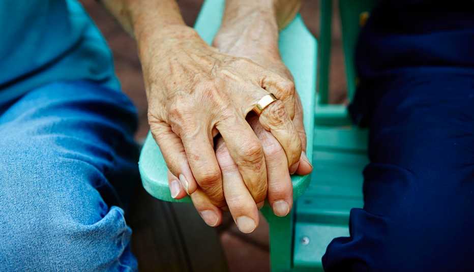 closeup of holding hands of an older couple