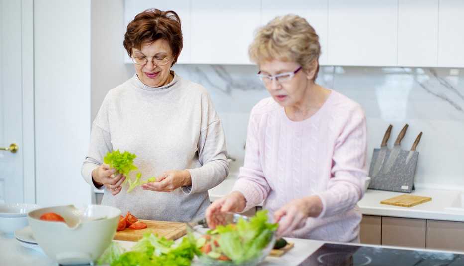 Two women preparing a salad at home.
