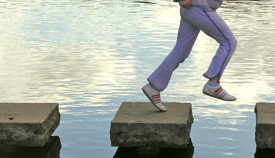 person jogging on stepping stones over a body of water