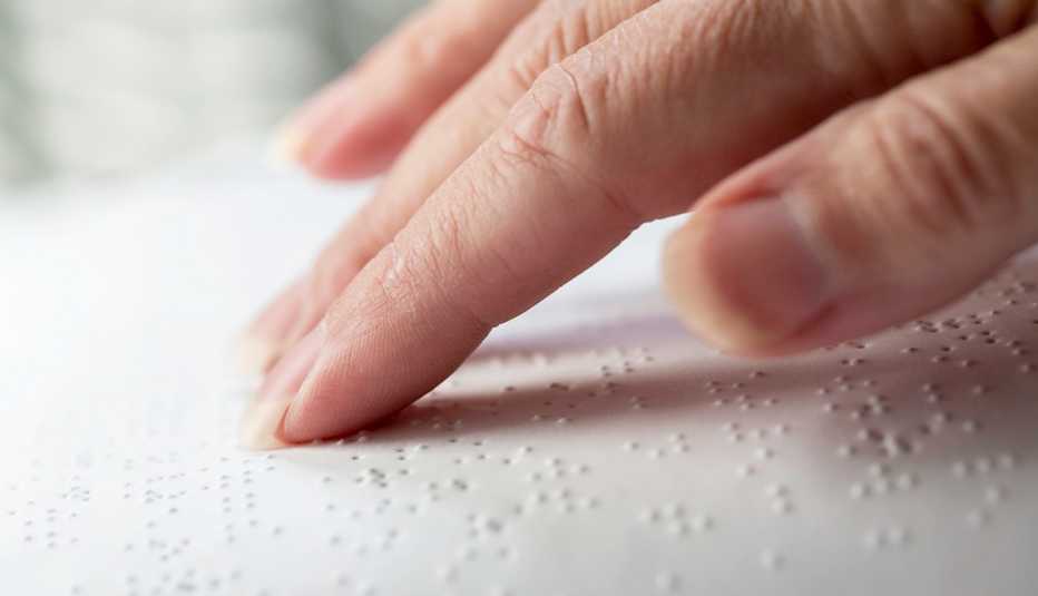 persons hand reading braille book