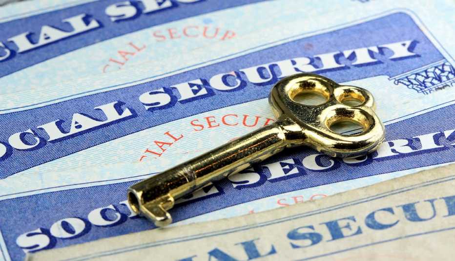 gold key laying on social security cards