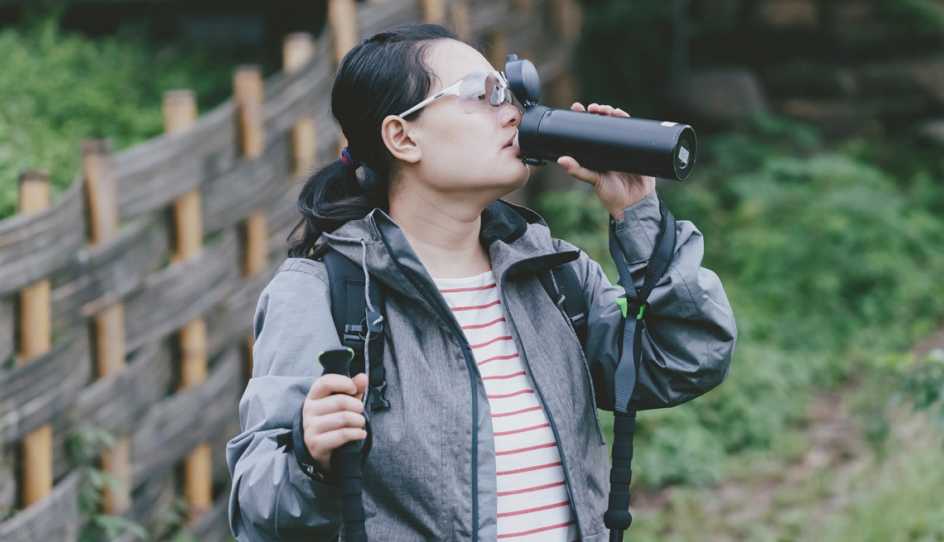 woman hiking drinking water
