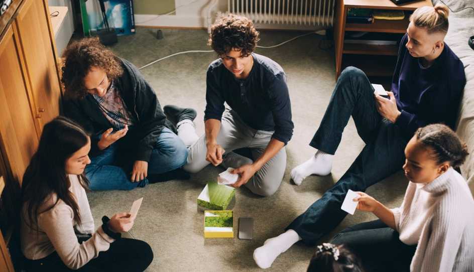 teens sitting in a group playing a game