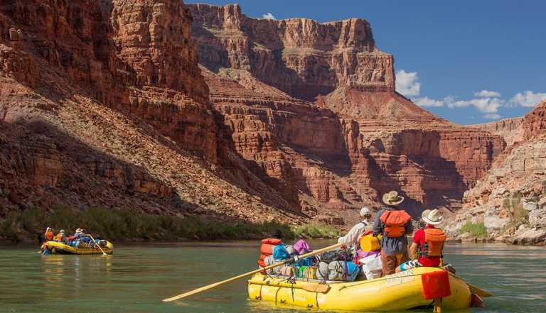 whitewater rafts below steep canyon walls on Colorado River at Grand Canyon National Park
