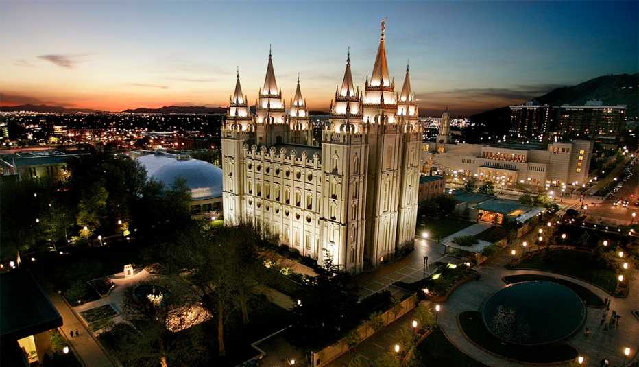the mormon temple in salt lake city is lit up at sunset