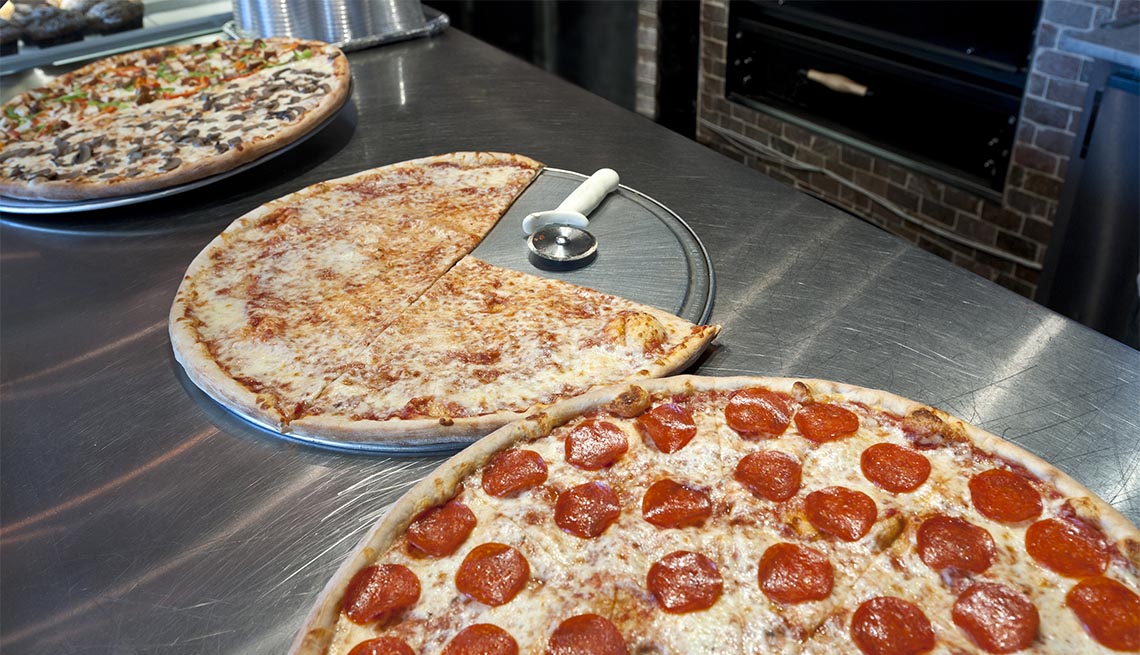 Three giants pizzas in a new york pizzeria counter