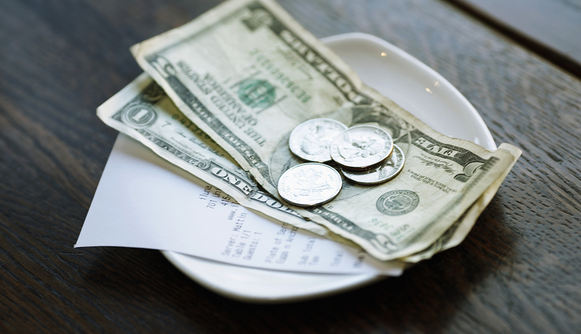 Dollars and Coins Change, Receipt in Change Dish, How to Tip When You're Traveling in the U.S.