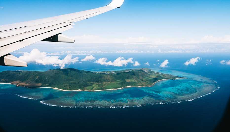 Flying over a tropical island with coral reefs