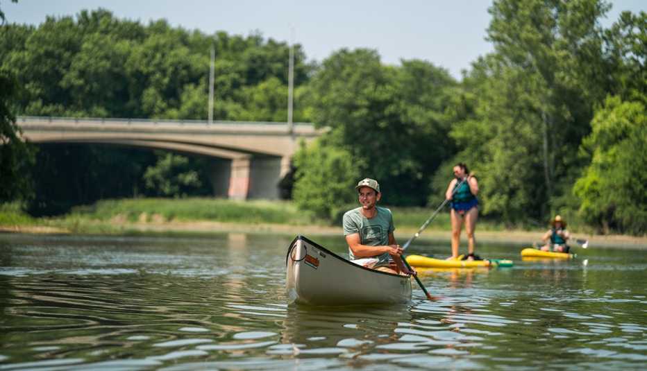 people canoeing and paddleboarding on the white river in indianapolis indiana
