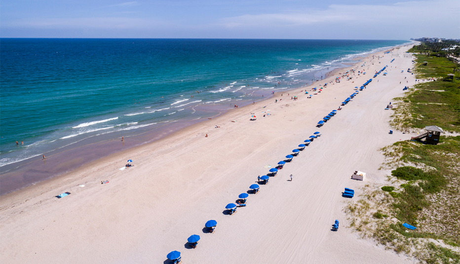 beach umbrellas and people sunbathing on delray beach in florida