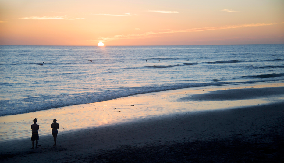 couple walking on the beach at sunset in encinitas california