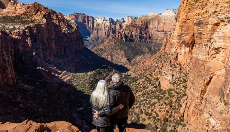 a couple overlooking a canyon in zion national park in utah