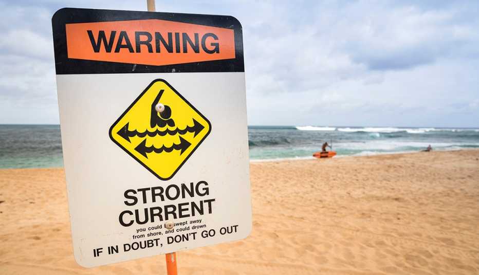 Sign on the beach that reads: Warning: Strong Current. If in doubt, don't go out