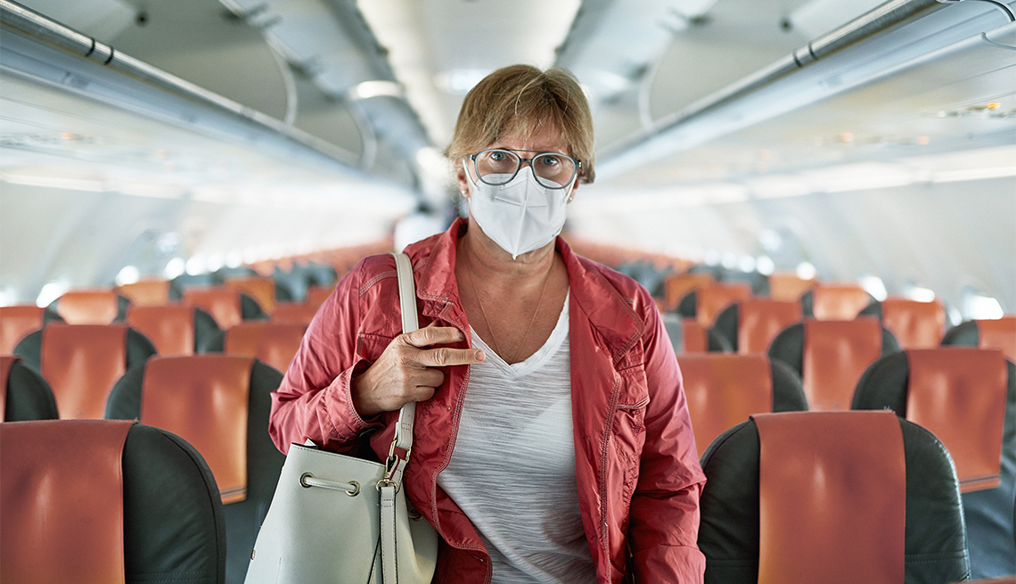woman in eyeglasses, protective mask, and casual clothing exiting empty airplane 
