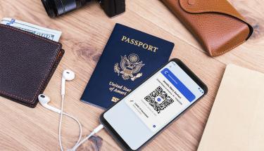 Travel items with CommonPass app displayed
