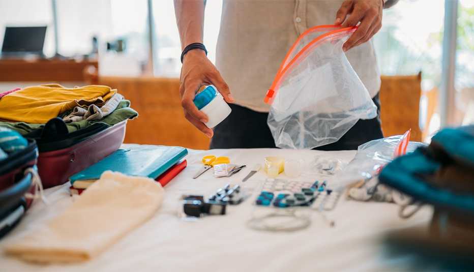 A man packs tablets and vitamins in transparent plastic bags with a zipper.