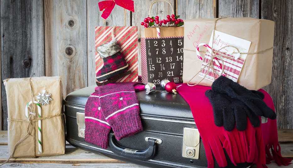 holiday gifts, gloves and scarf, on top and around black luggage
