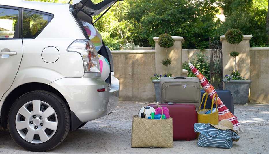 Car with trunk door open and beach items and luggage