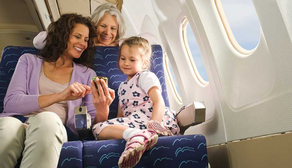 Family looking at cell phone aboard airplane
