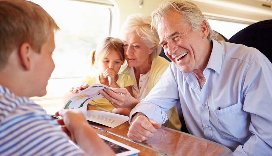 Grandparents And Grandchildren Relaxing On Train Journey