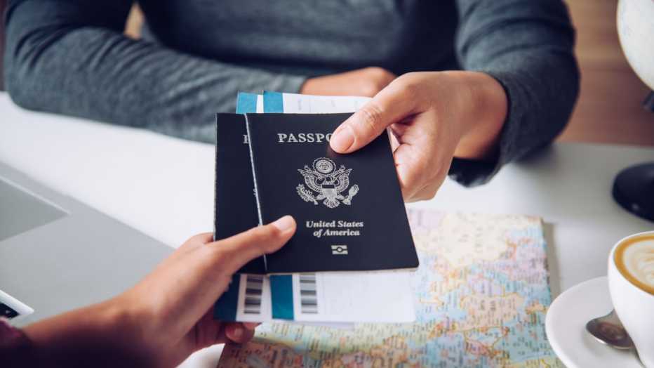 Two US passport being handed over from one person to another can only see hands