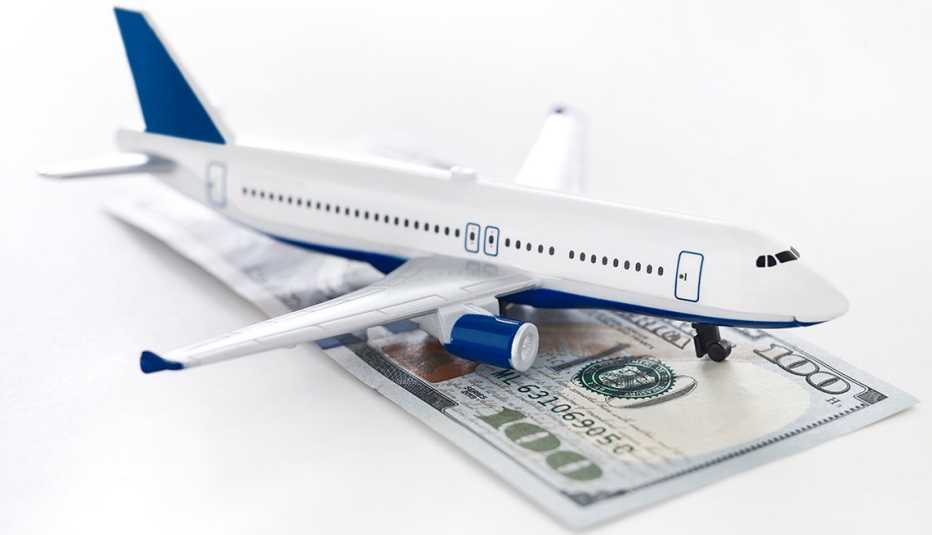 Toy plane on a desktop with a pile of 100 dollar bills