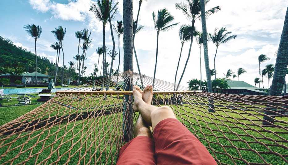 a man's point of view while relaxing in a hammock amid palm trees