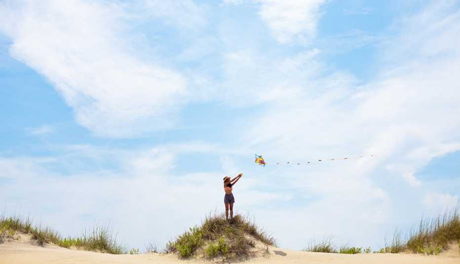 A woman flying a kite on a beach in the Outer Banks