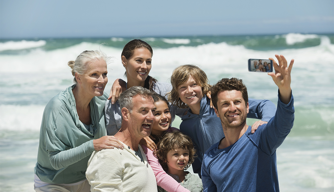 multi-generational family taking a selfie on a beach