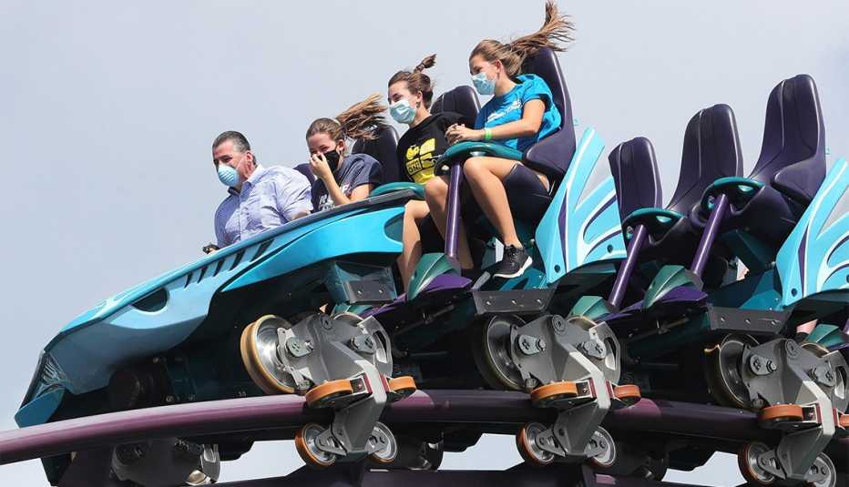 Sea World Orlando guests don masks to ride the Mako roller coaster, in Orlando, Fla.