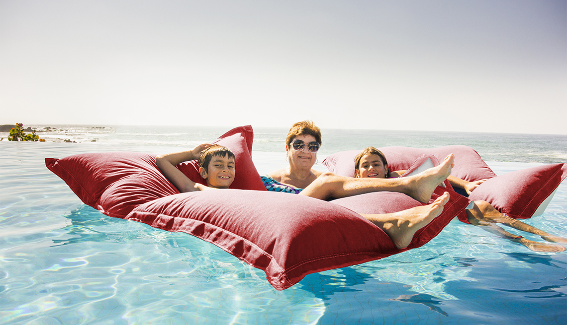 Grandmother and grandchildren relaxing on pool raft