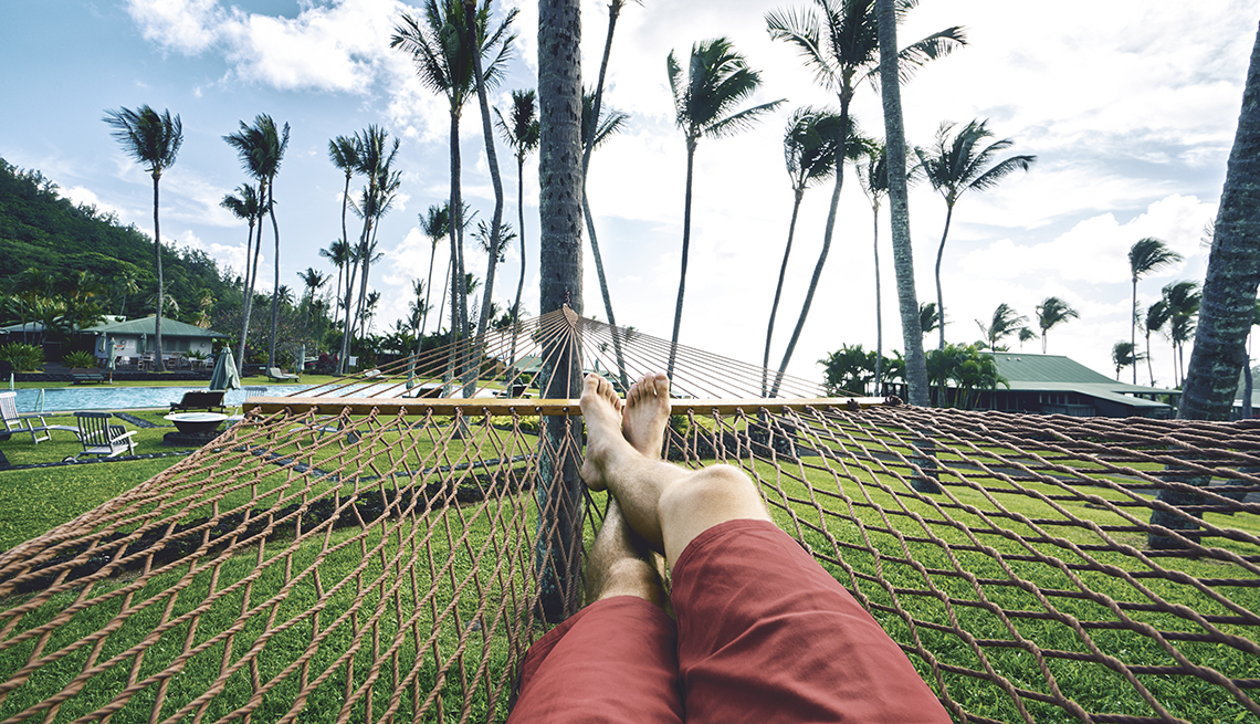 a man's point of view while relaxing in a hammock amid palm trees