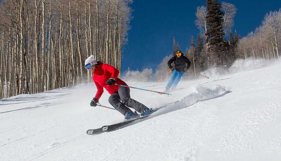 Two skiers skiing down a hill at Deer Valley Resort