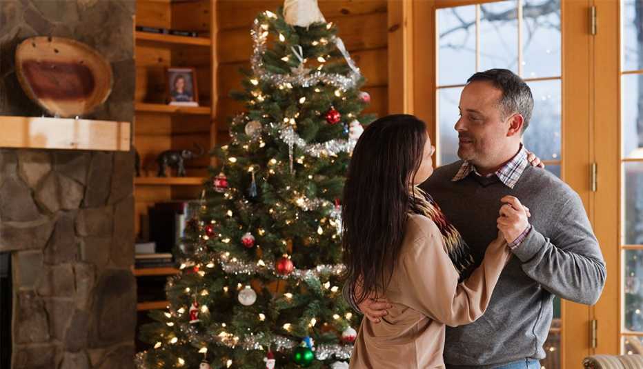 couple slow dancing near a Christmas tree