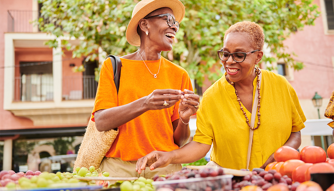 two women browsing fresh fruit and vegetables at a farmers market