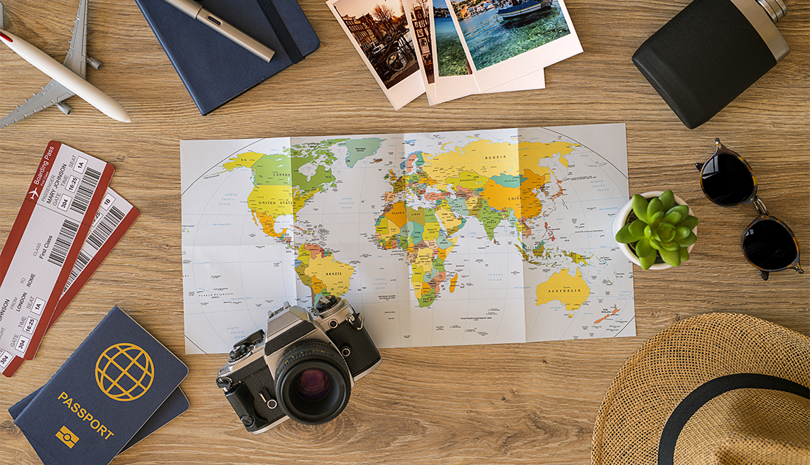Travel stuff on desktop: map, sun glasses, camera, tickets, passport etc.