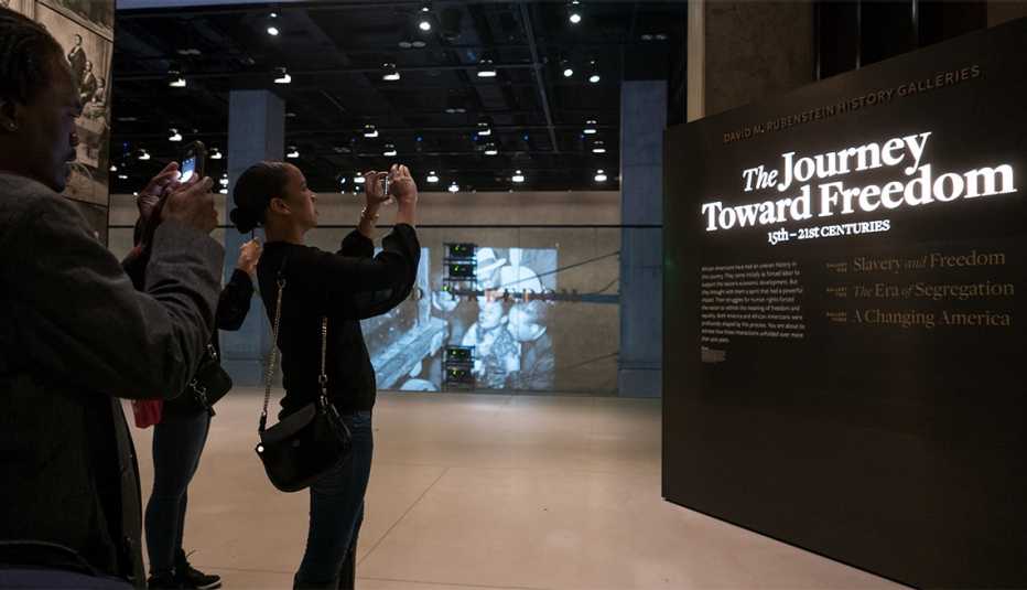 Guests tour the Slavery and Freedom exhibit at the Smithsonian's National Museum of African American History and Culture (NMAAHC)